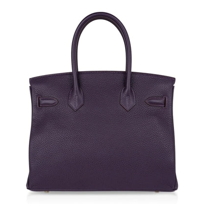 Deep Raisin Purple Medium Structured Top Handle Tote With Full Pebbled Grain Surface, Polished Golden Twist Hardware And Matching Lock Tassel Pendant Set